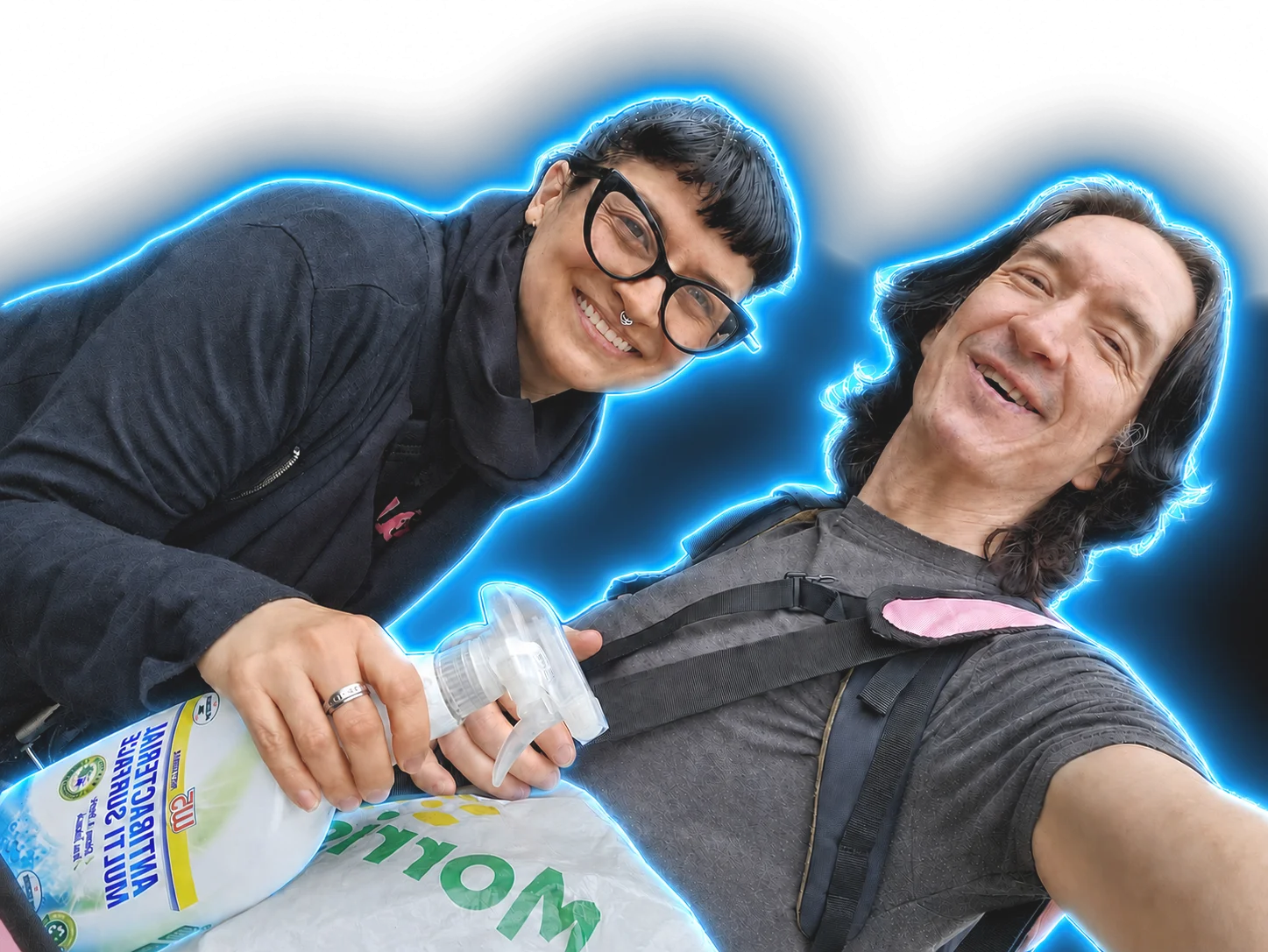 David and Kari smiling mid cleaning shift, spray bottle and shopping bag in hand, outlined in electric blue